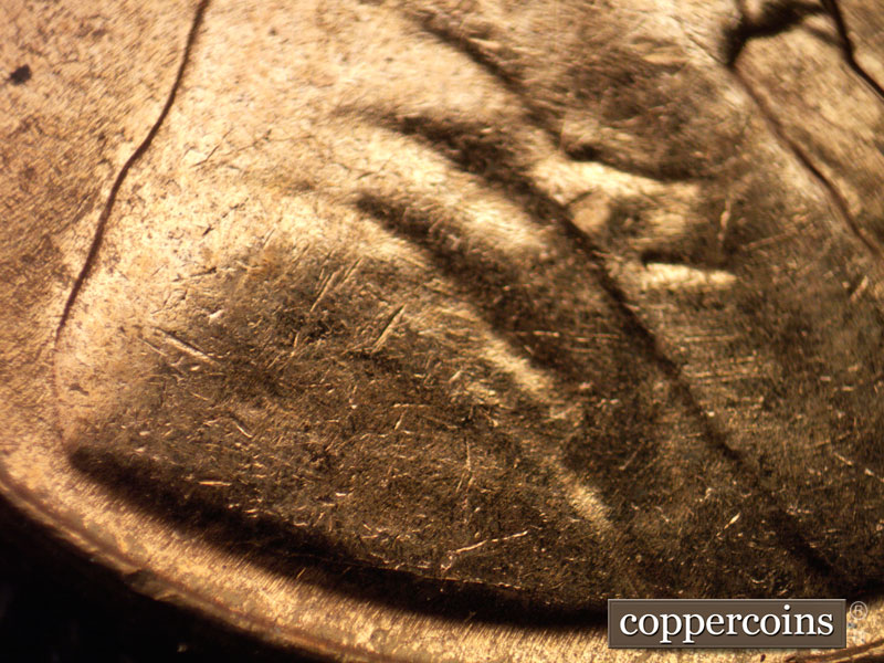 Die-stage B marker on 1960D•1MM•025 showing Light concentric die scratches on vest. Die crack over VDB.