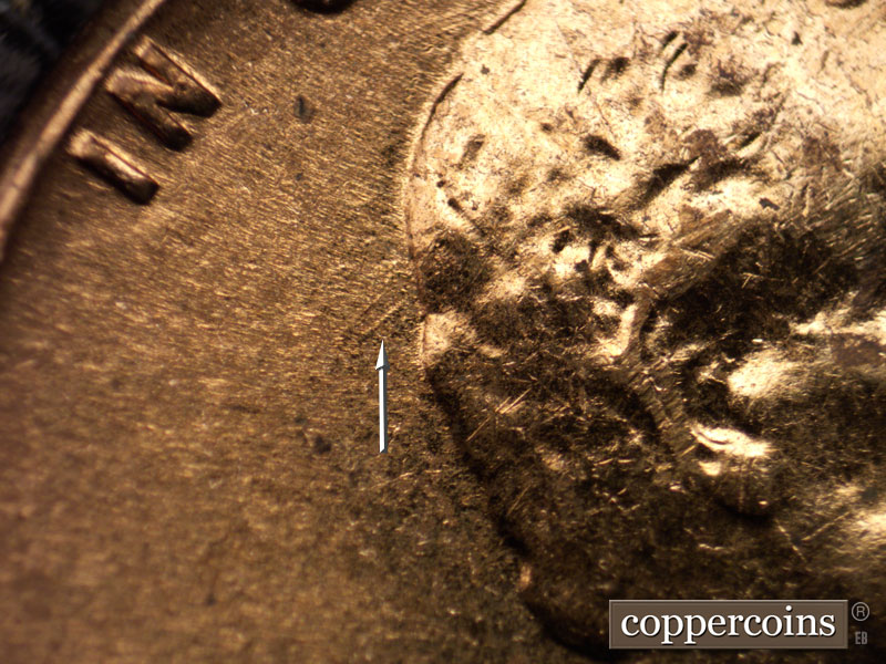 Die-stage B marker on 1960D•1MM•025 showing SW die gouge from back of hair.