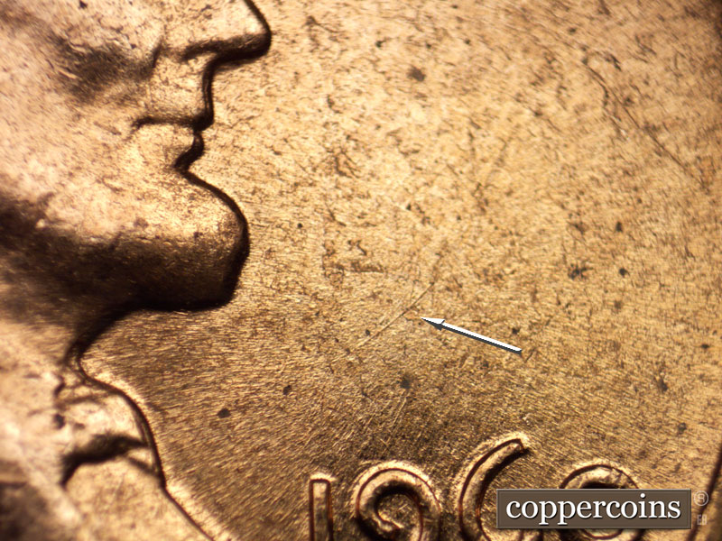 Die-stage B marker on 1960D•1MM•025 showing NE die scratch east of chin.