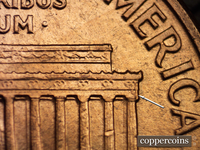 Die-stage B marker on 1960D•1MM•025 showing Small die chip right cornice.