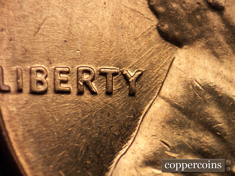 Die-stage C marker on 1960D•1MM•025 showing NE die scratches through RTY in LIBERTY to back of head.