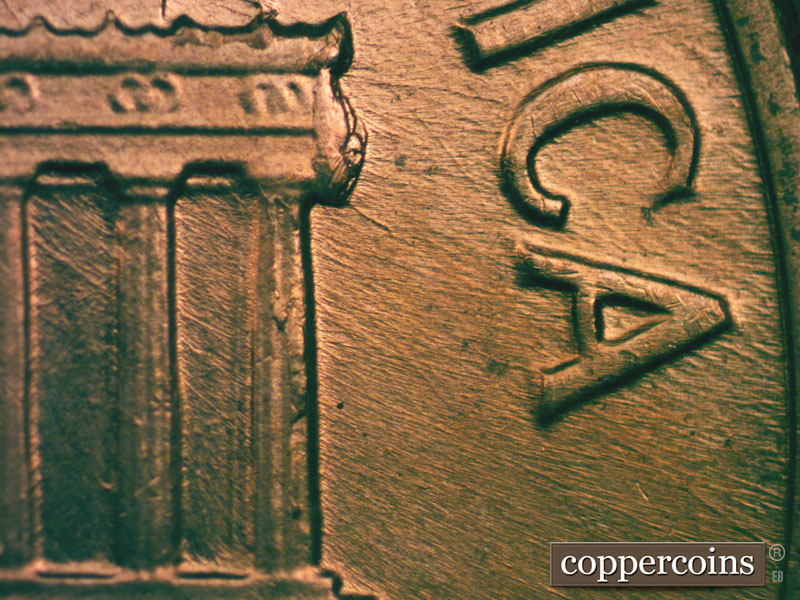 Die-stage B marker on 1960D•1MM•027 showing A large die break at the right cornice.