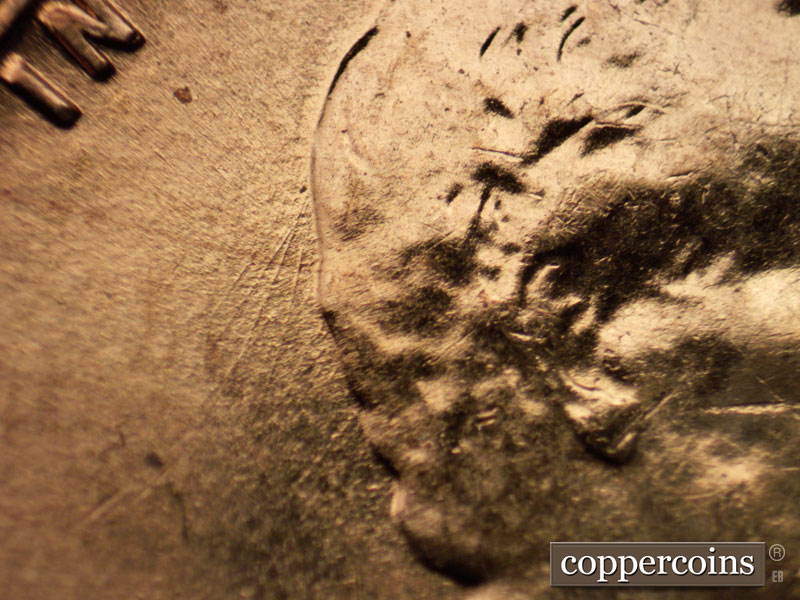 Die-stage A marker on 1960D•1MM•028 showing SW die scratches from back of hair.