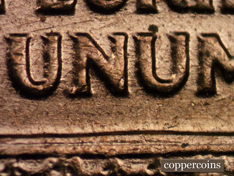 Die-stage B marker on 1960D•1MM•029 showing ENE die scratches between PLURIBUS and UNUM.