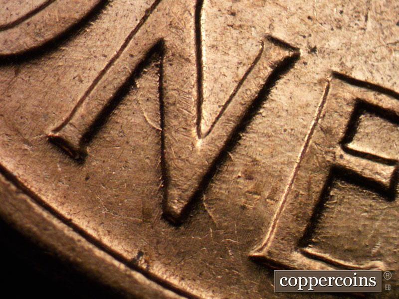 Die-stage B marker on 1960D•1MM•029 showing Unique die scratch through N in ONE.