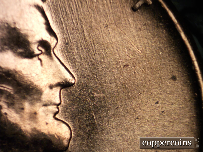Die-stage B marker on 1960D•1MM•030 showing SSE die scratches in front of face.