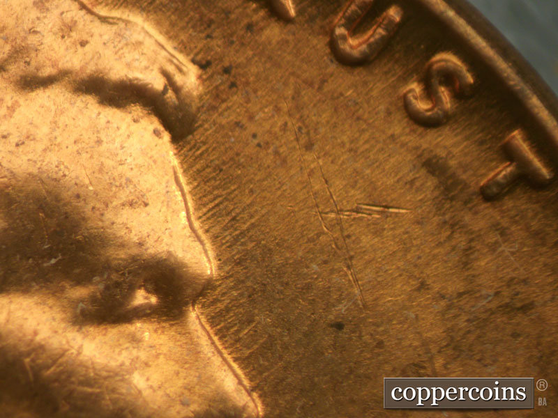 Die-stage B marker on 1960D•1MM•032 showing NE die scratches from front of forehead.