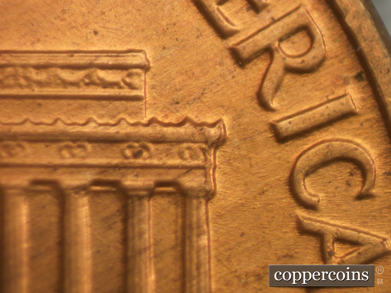 Die-stage B marker on 1960D•1MM•032 showing Die chipping on right cornice.