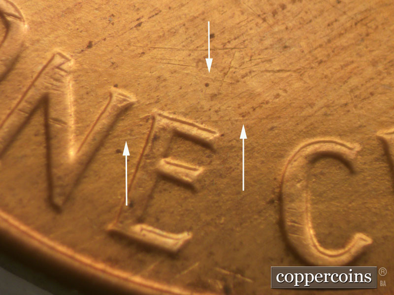 Die-stage B marker on 1960D•1MM•032 showing Long die scratch above ONE.