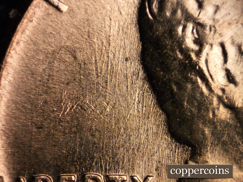 Die-stage B marker on 1960D•1MM•033 showing N/S die scratches behind head.