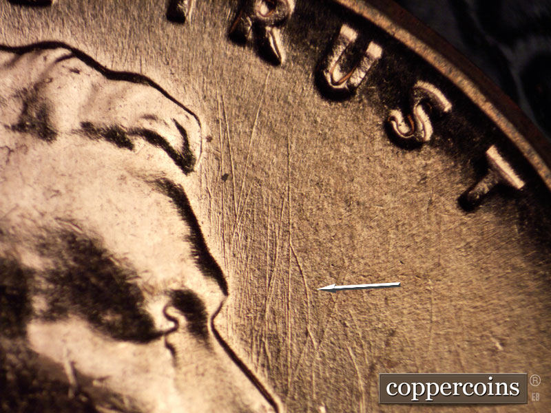 Die-stage C marker on 1960D•1MM•033 showing Curved die scratch in front of forehead.