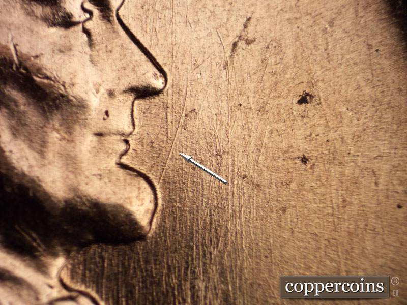 Die-stage C marker on 1960D•1MM•033 showing NE die scratch from chin.