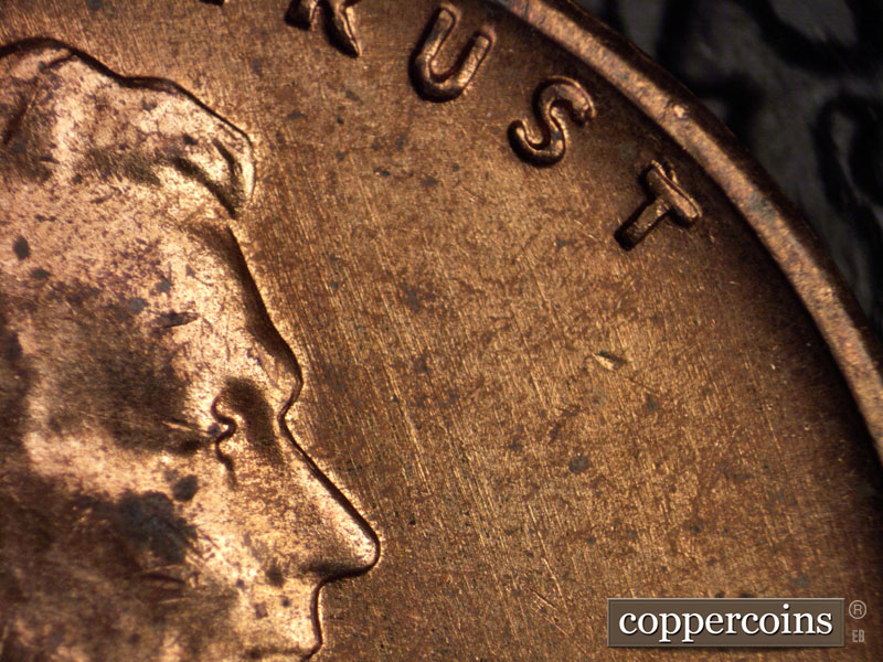 Die-stage B marker on 1960D•1MM•035 showing Die scratches run SE in front of face.