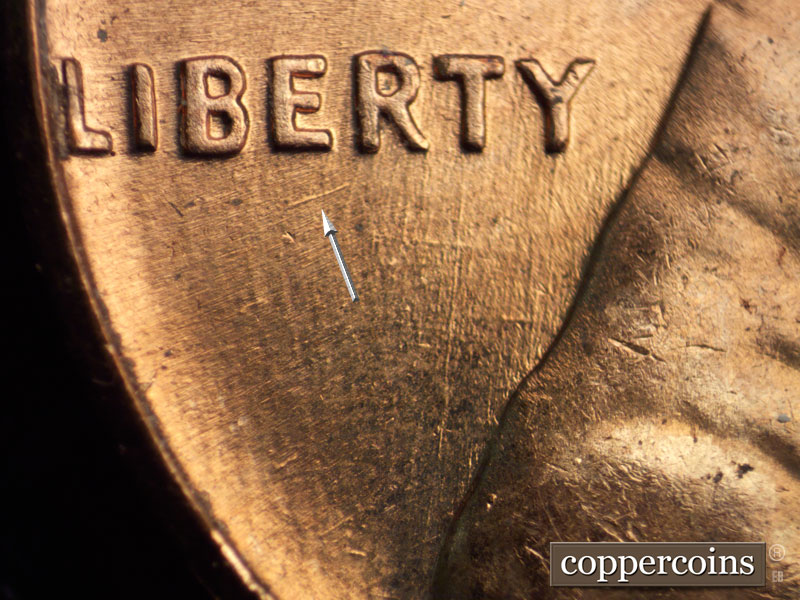 Die-stage B marker on 1960D•1MM•037 showing SW die scratch under LIBERTY.
