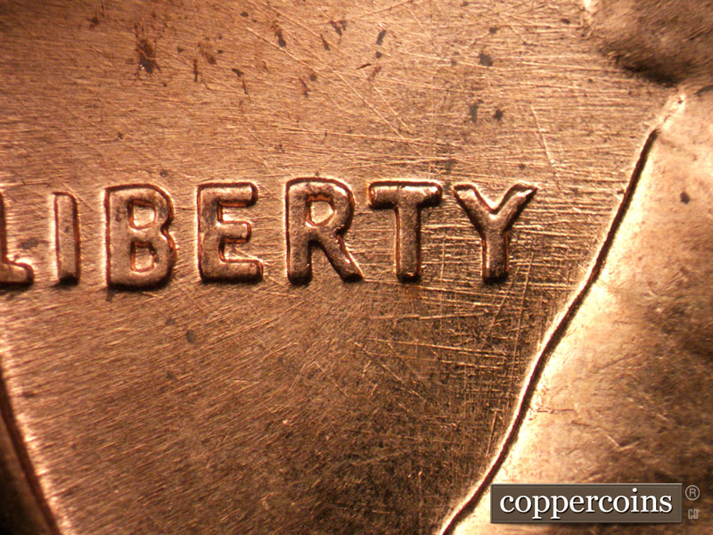 Die-stage C marker on 1960D•1MM•037 showing Crossing die scratches through RTY in LIBERTY.