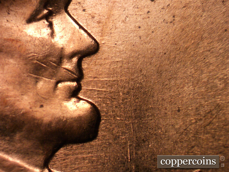 Die-stage C marker on 1960D•1MM•037 showing E/W die scratches from mouth.