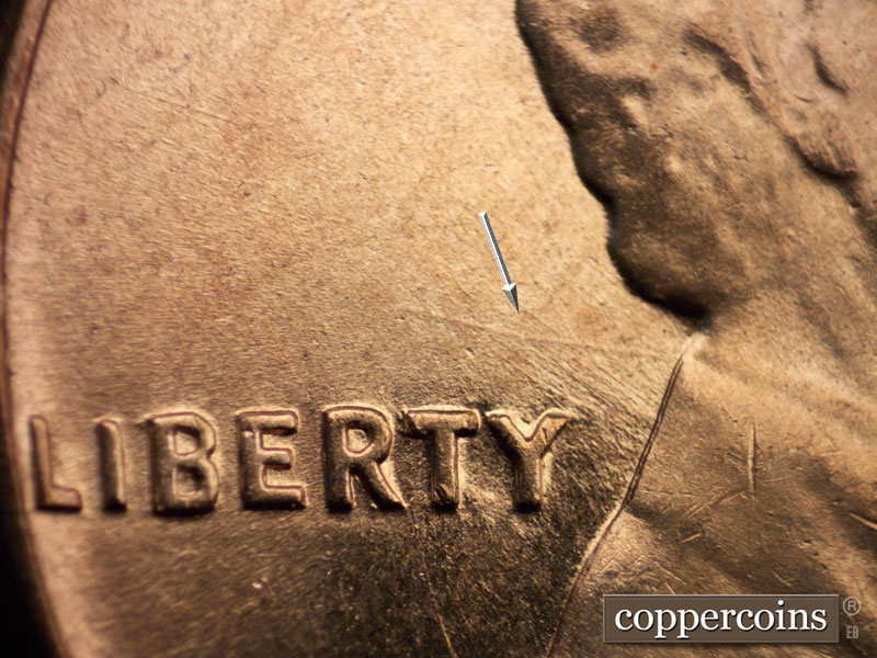 Die-stage B marker on 1960D•1MM•039 showing A die scratch runs NW from the back of the collar below the T of LIBERTY.