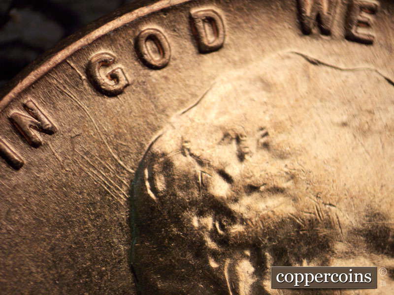 Die-stage B marker on 1960D•1MM•039 showing Die gouges from the rim between IN GOD to the top of the head.