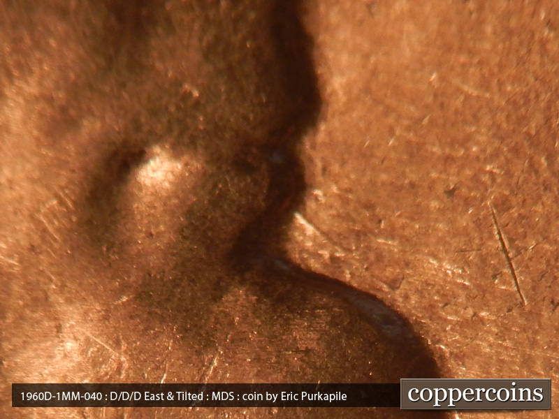 Die-stage B marker on 1960D•1MM•040 showing A die scratch runs SE from the lower lip.