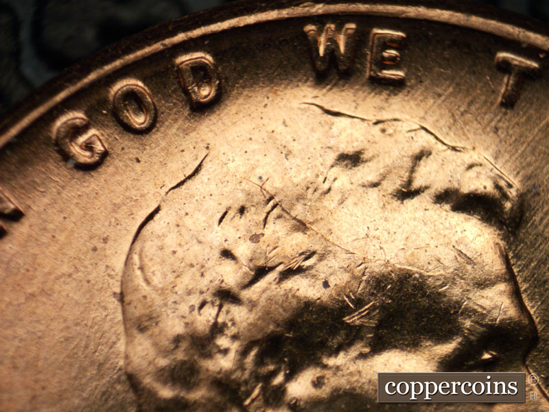 Die-stage B marker on 1960D•1MM•042 showing Die crack on forehead into hair.