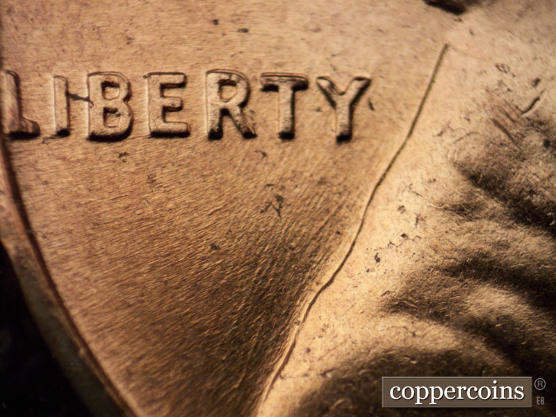 Die-stage C marker on 1960D•1MM•042 showing SSW die scratches in field under LIBERTY.