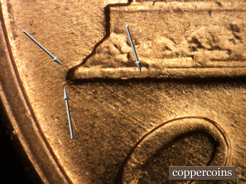 Die-stage A marker on 1960D•1MM•047 showing Die crack on right base. SW die scratches from left base tip. SE die scratches from base to O in ONE.