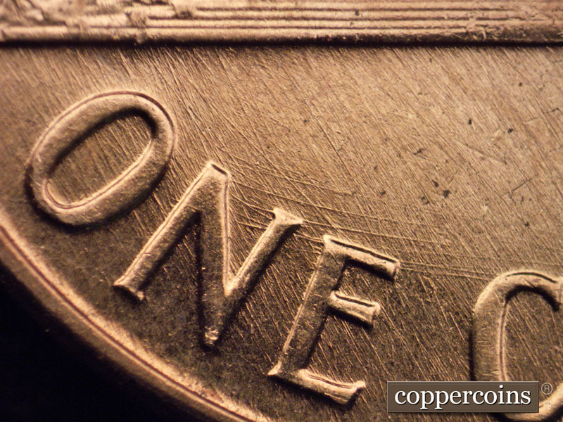 Die-stage A marker on 1960D•1MM•048 showing Heavy curved die scratches through and above NE in ONE.
