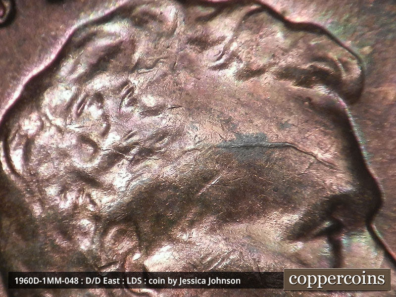 Die-stage C marker on 1960D•1MM•048 showing A heavy die crack runs through the forehead into the hair to the west.