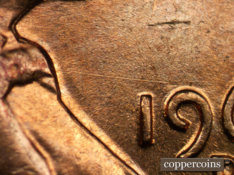 Die-stage A marker on 1960D•1MM•049 showing Heavy die scratch from bowtie to top of 9 in date.