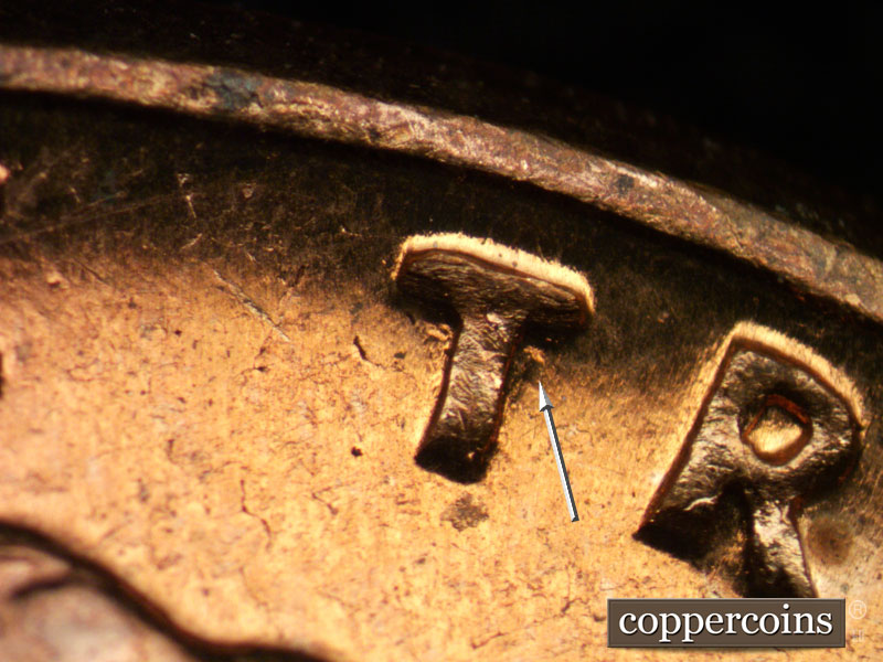 Die-stage A marker on 1960D•1MM•049 showing Die gouge next to first T in TRUST.