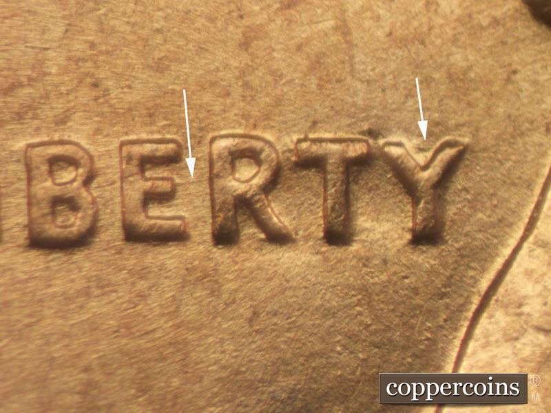Die-stage B marker on 1960D•1MM•049 showing Light horizontal die scratch connects ER of LIBERTY. Light scratch in upper arms of Y on LIBERTY.