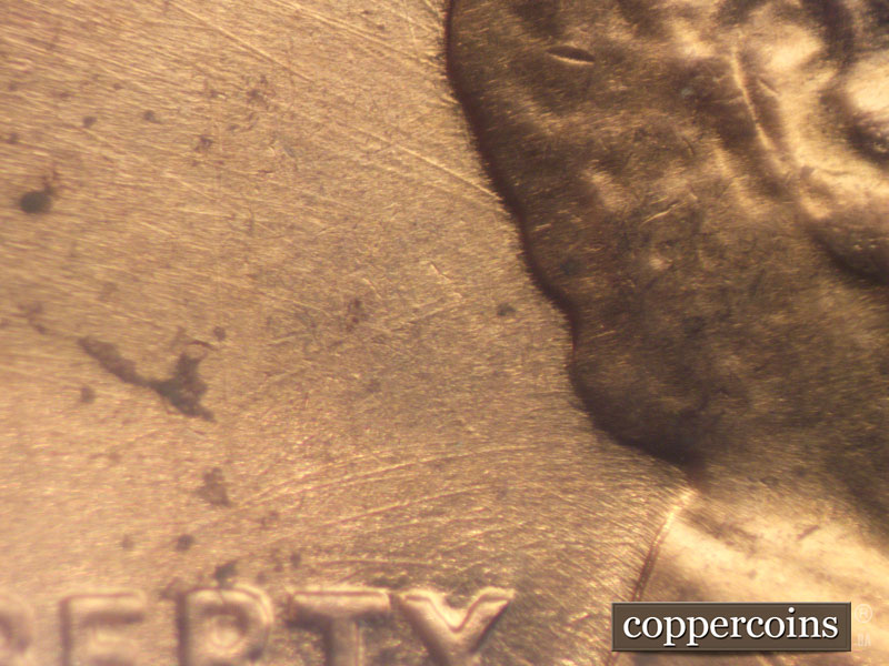 Die-stage B marker on 1960D•1MM•050 showing NW die scratches from back of hair.