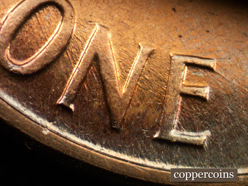 Die-stage C marker on 1960D•1MM•050 showing NW die scratches through ONE.