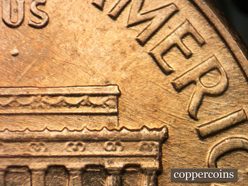Die-stage B marker on 1960D•1MM•053 showing Curved die scratches through RI in AMERICA.
