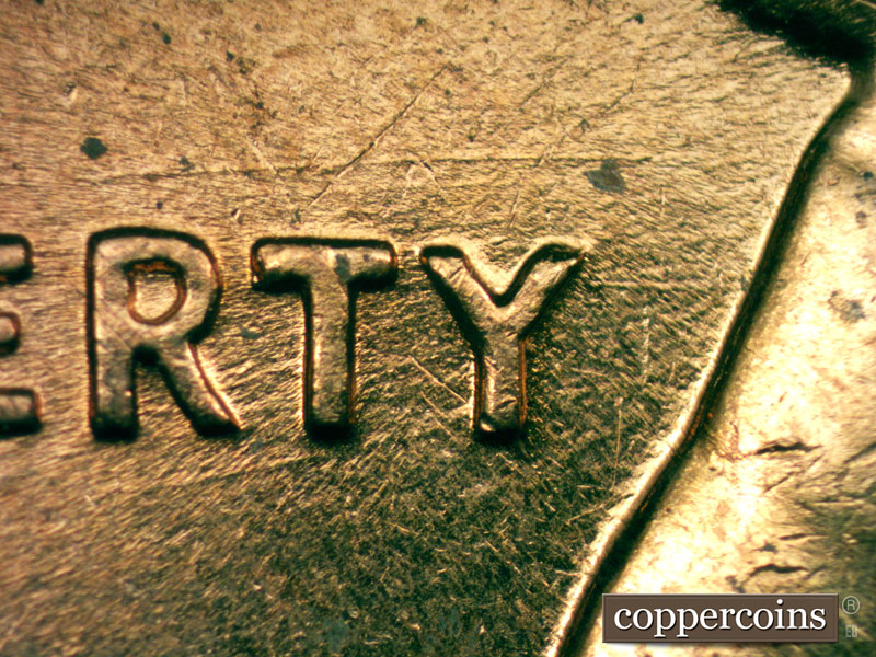 Die-stage C marker on 1960D•1MM•053 showing E/W die scratches above RTY in LIBERTY.