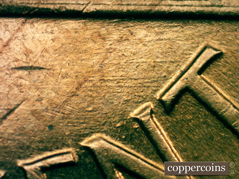 Die-stage C marker on 1960D•1MM•053 showing E/W die scratches below right base.