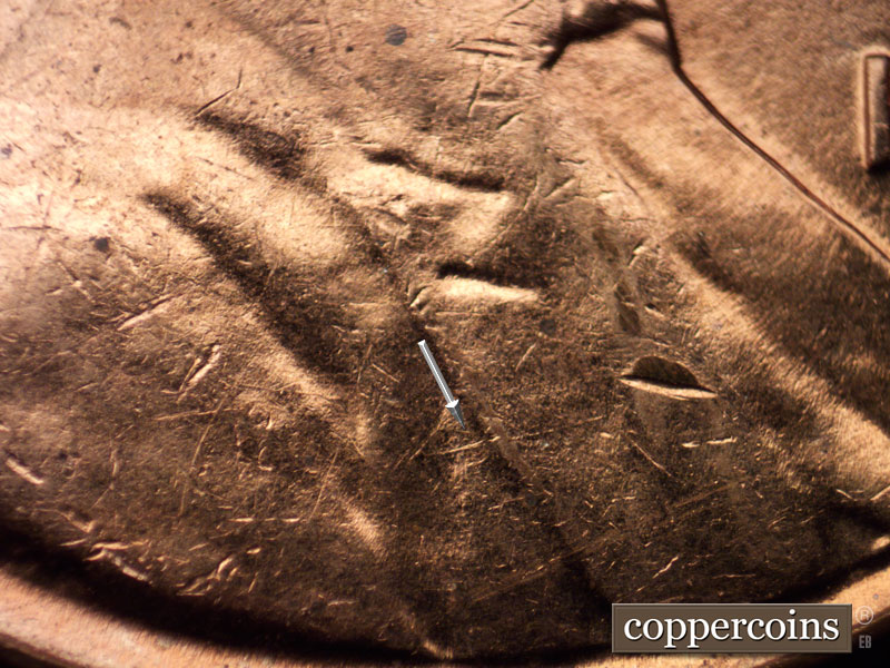 Die-stage B marker on 1960D•1MM•058 showing ENE die gouge from shoulder into lapel.