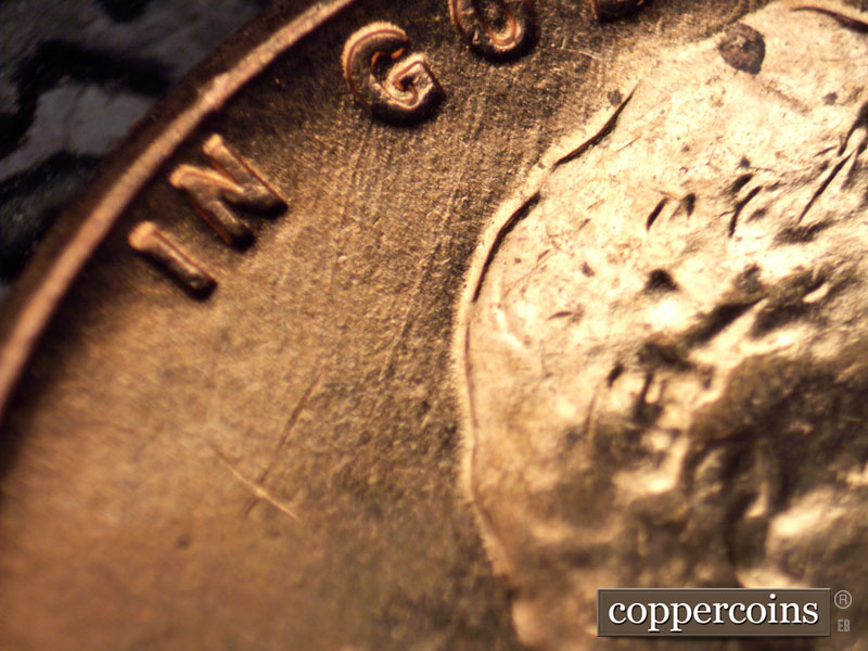 Die-stage C marker on 1960D•1MM•060 showing A medium die scratch runs southwest from the O of GOD.