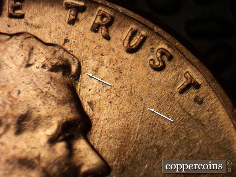 Die-stage B marker on 1960D•1MM•061 showing NNE die scratch from forehead toward R in TRUST.