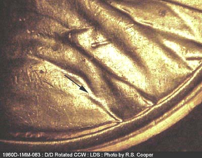 Die-stage C marker on 1960D•1MM•063 showing Several light die scratches in armfold in circular direction.