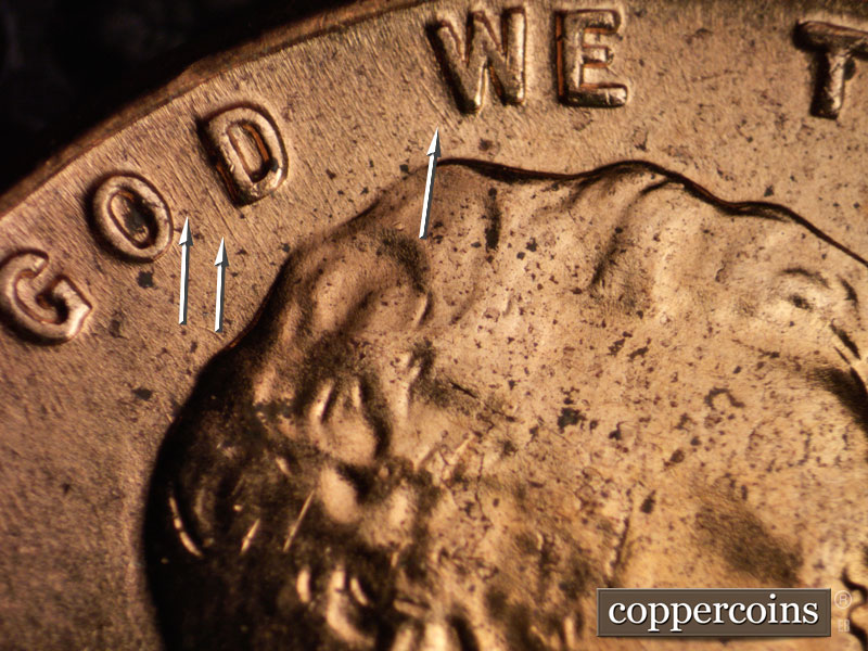 Die-stage A marker on 1960D•1MM•064 showing Pair of NNW die gouges between OD in GOD. NNW die gouge left of W in WE.