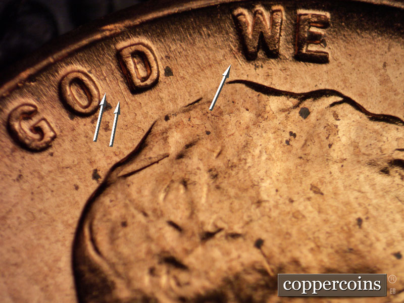 Die-stage B marker on 1960D•1MM•064 showing Pair of NNW die gouges between OD in GOD. NNW die gouge left of W in WE.