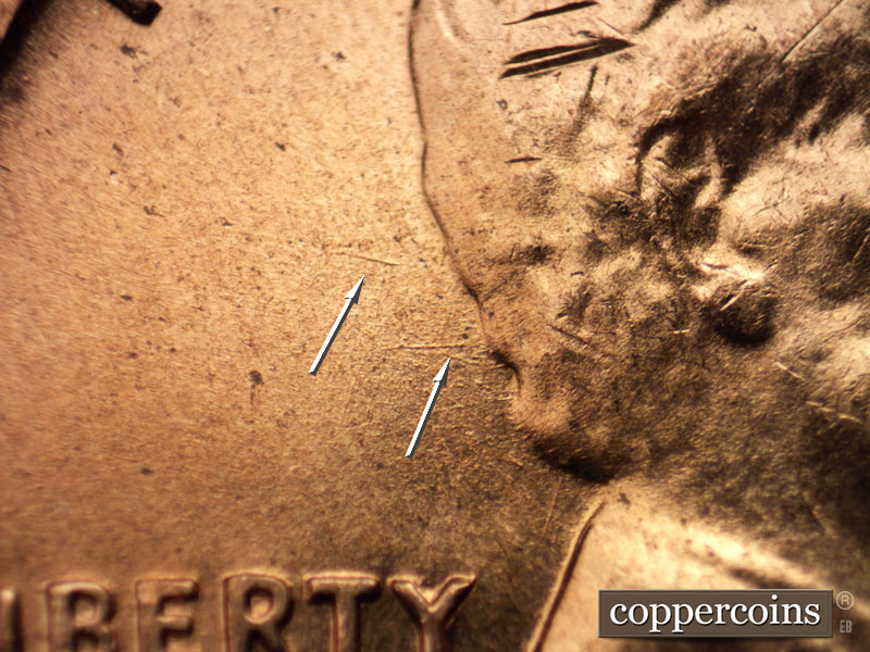 Die-stage B marker on 1960D•1MM•065 showing E/W die gouge from back of hair.