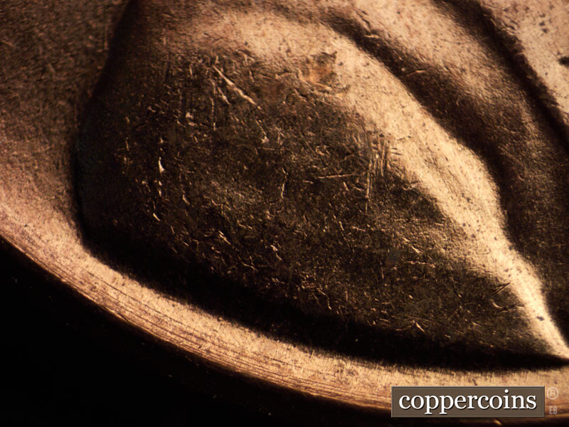Die-stage B marker on 1960D•1MM•065 showing Concentric die gouges show under the bust.