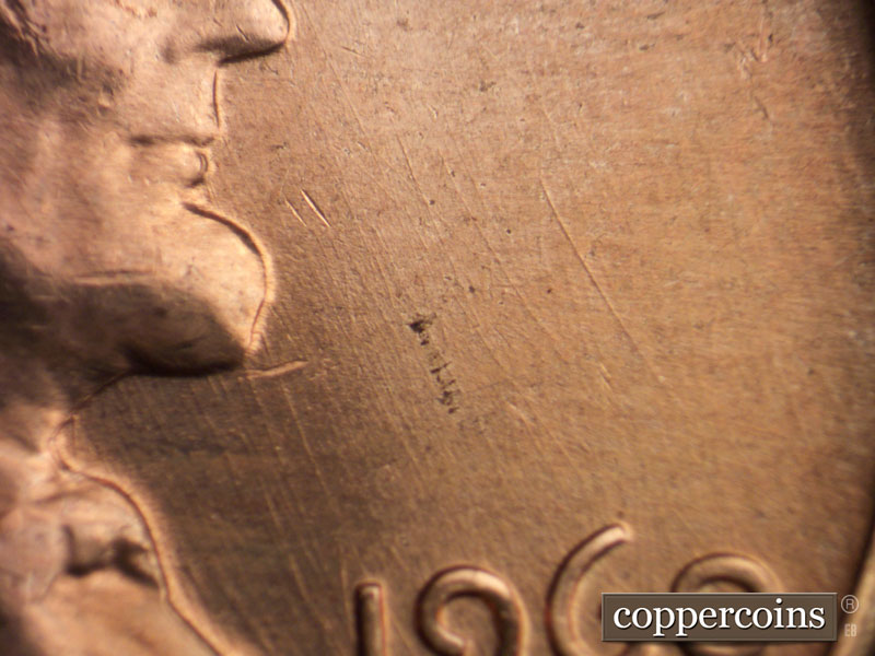 Die-stage C marker on 1960D•1MM•072 showing Multiple generally NNW die scratches through 19 in date.