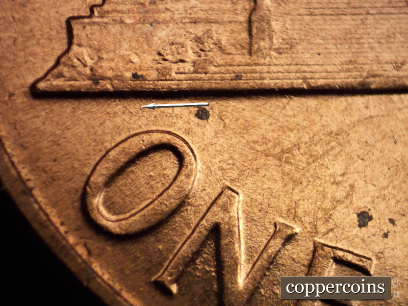 Die-stage B marker on 1960D•1MM•073 showing Small die gouge under left base toward O in ONE.