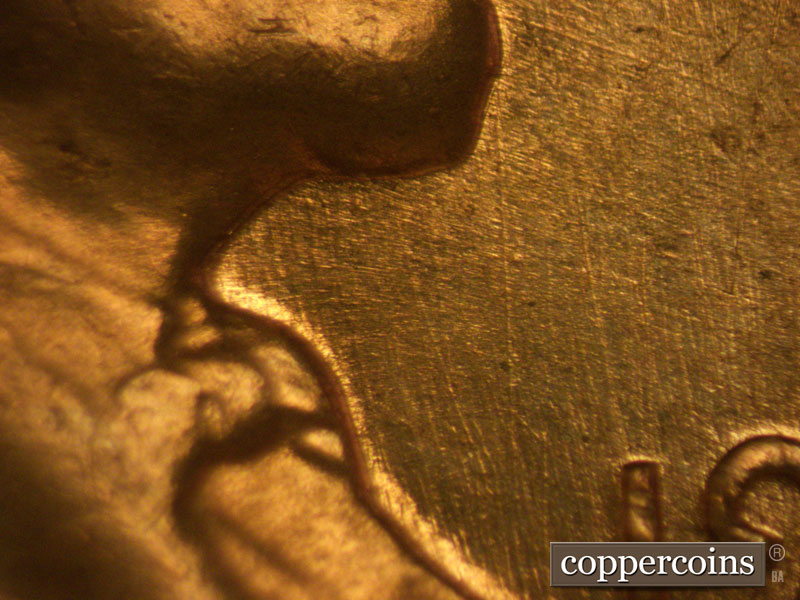 Die-stage B marker on 1960D•1MM•077 showing N/S die scratches under chin.