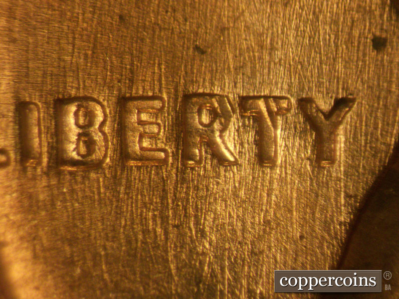 Die-stage B marker on 1960D•1MM•077 showing N/S die scratches through LIBERTY.