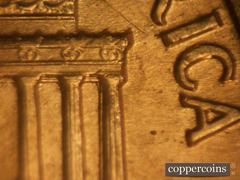 Die-stage B marker on 1960D•1MM•077 showing A large die dent to the right of the upper 12th column and cornice.