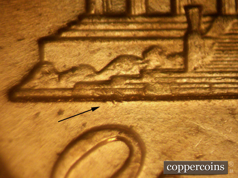Die-stage B marker on 1960D•1MM•077 showing Three small die gouges protruding from the left memorial foundation just above the O of ONE.